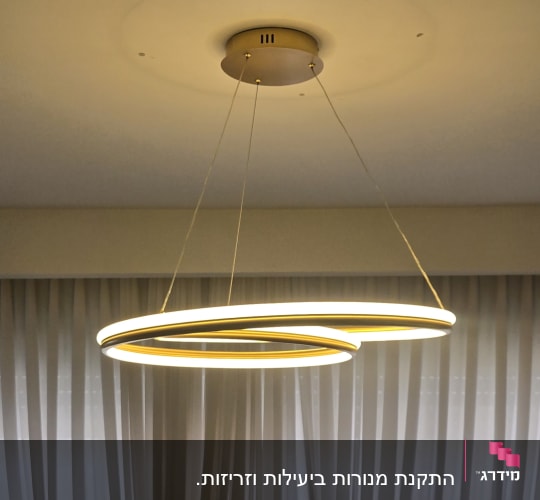 מנורת תקרה עגולה תלויה בחדר עם וילונות לבנים